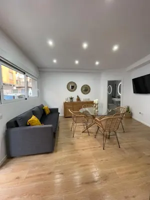 a living room with a couch and a table and chairs at UIM Mediterraneo PB Virgen del Carmen Wifi in Puerto de Sagunto