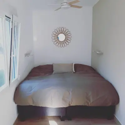a bed in a bedroom with a mirror on the wall at Casa Vitalis in Vilamarxant