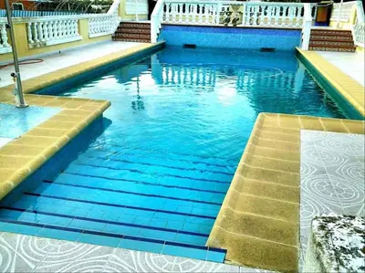 a swimming pool with blue water and stairs in it at Casa Con Piscina Privada Marenyet in Cullera