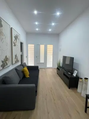 a living room with a couch and a flat screen tv at UIM Mediterraneo CASA Virgen de los Dolores Wifi in Puerto de Sagunto