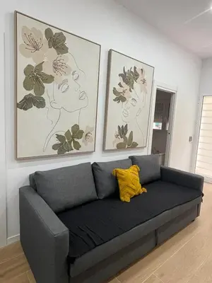 a couch in a living room with two pictures on the wall at UIM Mediterraneo CASA Virgen de los Dolores Wifi in Puerto de Sagunto