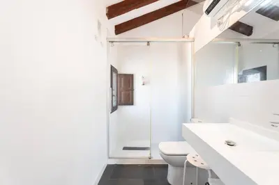a white bathroom with a toilet and a shower at 1893 Hotel Boutique in Navajas