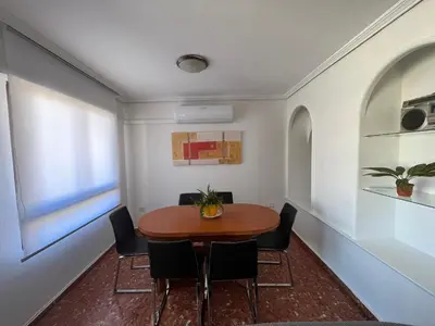 a dining room with a wooden table and chairs at Borriana Bonica in Burriana