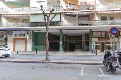 a building on a street with a motorcycle parked in a parking lot at Torremar, D-13-25 in Cullera