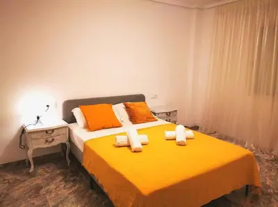 a bedroom with a yellow bed with towels on it at Great 4 bedrooms apartament in Puerto de Sagunto - Full Apartment - 120m2 in Puerto de Sagunto