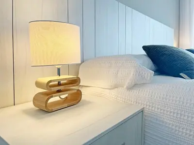 a lamp on a table next to a bed at Global Vacacional, Moderno apartamento con 2 terrazas y 3 habitaciones in Canet de Berenguer