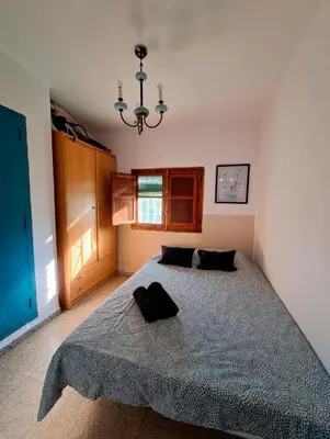 a bedroom with a bed and a chandelier at Buganvilla in Valencia