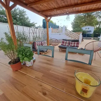 a wooden table with a drink on a patio at Buganvilla in Valencia