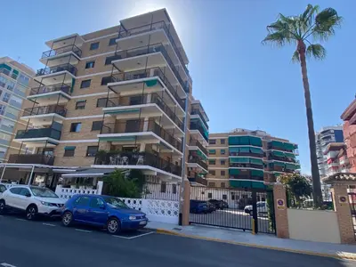 a tall apartment building with cars parked in front of it at Sun & Sea Puebla in Puebla de Farnals