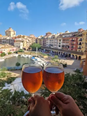 two people holding wine glasses with a view of a river at Port Saplaya 3 habitaciones Valencia in Port Saplaya