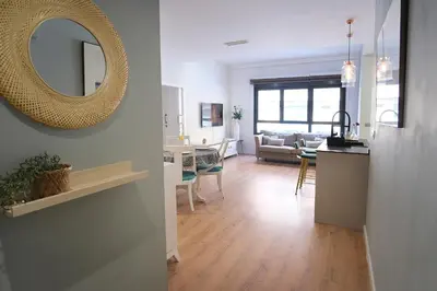 a living room and a kitchen with a mirror on the wall at Lujoso Hogar cerca del Casco Antiguo de la ciudad in Valencia