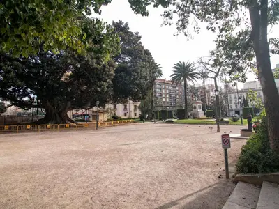 an empty parking lot with a tree and buildings at MD Iturbi Jardin Turia in Valencia