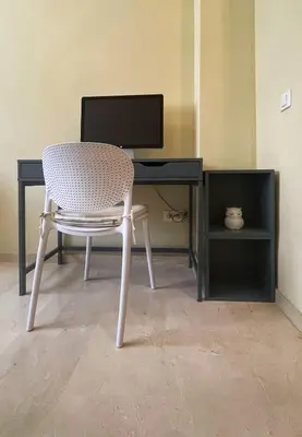 a chair in front of a desk with a computer monitor at Work and Rest Away From Home in Paterna