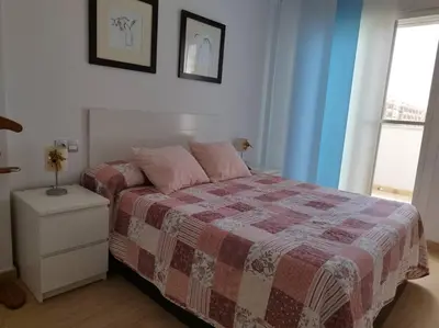 a bedroom with a bed with a blanket and a night stand at Villa de lujo frente al mar in Barrio-Mar