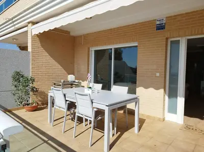 a white table and chairs on a patio at Villa de lujo frente al mar in Barrio-Mar