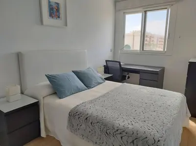 a bedroom with a bed and a desk and a window at Villa de lujo frente al mar in Barrio-Mar