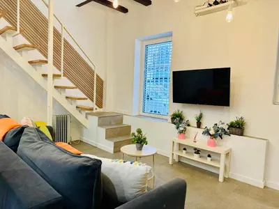 a living room with a couch and a flat screen tv at Design & Stylish House in the CENTER of Valencia in Valencia