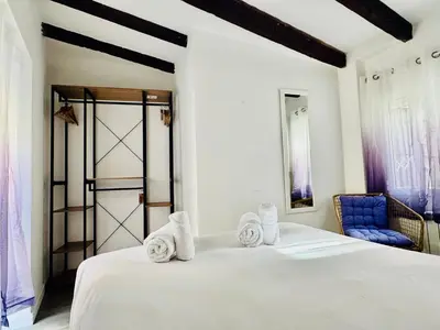 a bedroom with a white bed and a blue chair at Design & Stylish House in the CENTER of Valencia in Valencia