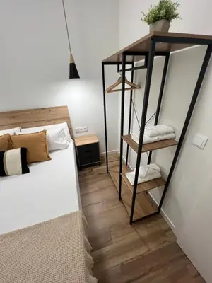 a bedroom with a black and white bed and a shelf at Beach Apartments Valencia in Valencia