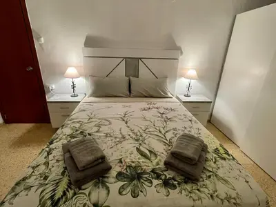 a room with a white table and a red couch at Sol y playa in Puerto de Sagunto