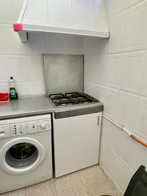a small kitchen with a stove and a washing machine at Sol y playa in Puerto de Sagunto