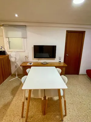 a room with a table and a desk and a television at Sol y playa in Puerto de Sagunto