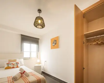 a bedroom with a bed and a pendant light at Macflats Ciudad de las Ciencias in Valencia