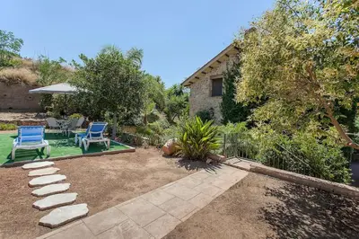 a yard with two blue chairs and a patio at VILLA TAMARIT in Pedralba