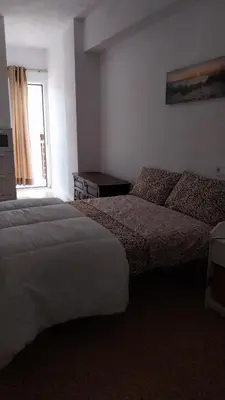 a hotel room with two beds and a window at Santa Marta frente al mar in Cullera