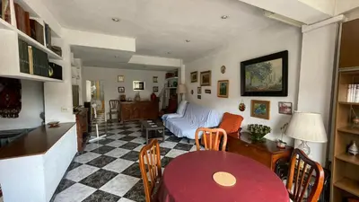 a kitchen and living room with a table and a couch at flat family near center and jardin turia avenida del cid in Valencia