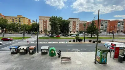 a city street with a bus stop and a parking lot at flat family near center and jardin turia avenida del cid in Valencia