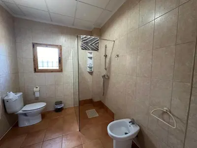 a bathroom with a toilet and a shower and a sink at Casa El Calderon in Chella