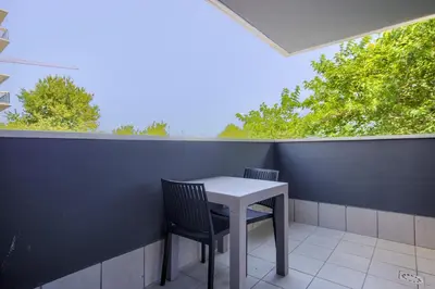 a table and chairs on a balcony with trees at Arena 20 Suites in Valencia