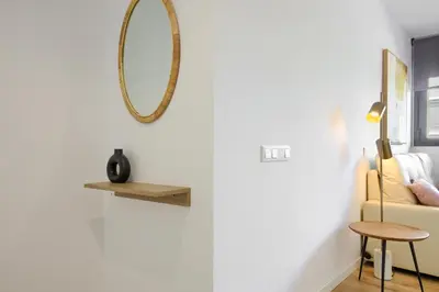 a living room with a mirror and a chair at Arena 20 Suites in Valencia