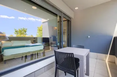 a bedroom with a bed and a table on a balcony at Arena 20 Suites in Valencia