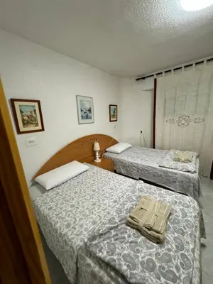 a hotel room with two beds with towels on them at Encantador piso cerca de la playa en Cullera in Faro de Cullera