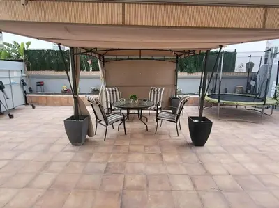 a patio with a table and chairs under a pavilion at Precioso apartamento reformado con terraza, 4 habs in Valencia