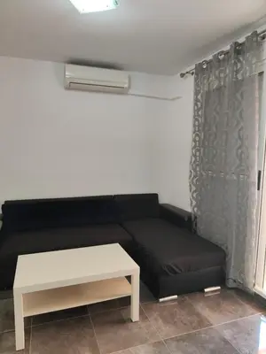 a living room with a black couch and a table at Mar i piscina Canet playa in Canet de Berenguer