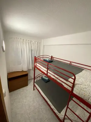 a red bunk bed in a room with a window at Beautiful apartment 1 minute walk to the beach in Puerto de Sagunto