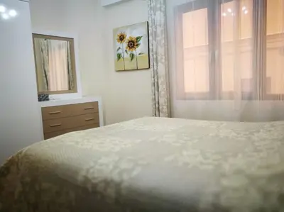 a white bedroom with a bed and a window at City center where Falla starts in Valencia