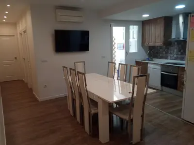 a kitchen and dining room with a wooden table and chairs at City center where Falla starts in Valencia