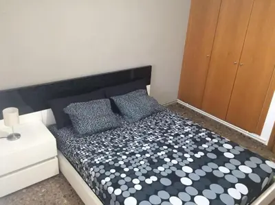 a bedroom with a bed with a black and white comforter at Apartamento cómodo y espacioso con parking in Valencia