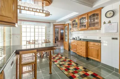 a kitchen with wooden cabinets and a large island at GuestReady - A un paso del Mediterráneo in El Puig