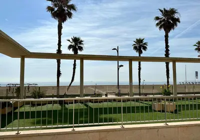 a view of the beach and palm trees from a building at Reinapart Patacona Beachfront Seaview in Valencia