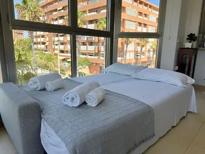 a bedroom with a large bed with towels on it at Reinapart Patacona Beachfront Seaview in Valencia