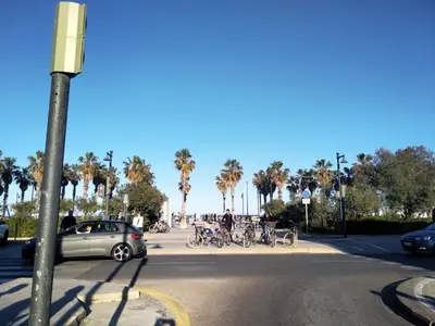 a car driving down a street with palm trees at Habitación en Playa Malvarrosa con baño privado -No AC- in Valencia