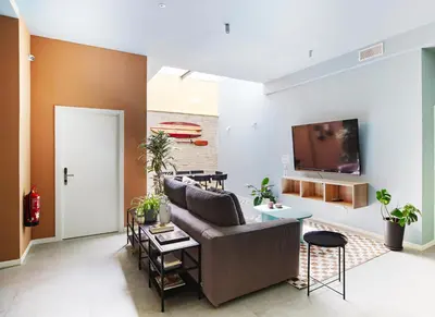 a living room with a couch and a tv at Habitación en Playa Malvarrosa con baño privado -No AC- in Valencia