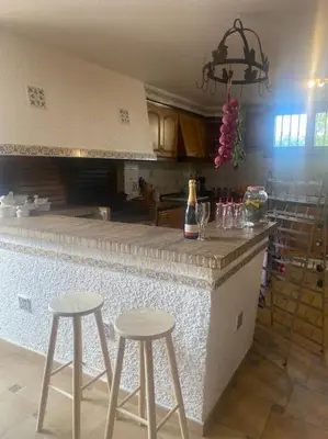 a kitchen with two bar stools and a counter top at Casa Ellenita in Las Canteras