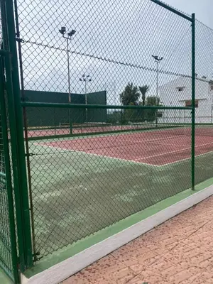 a tennis court seen through a chain link fence at Casa Ellenita in Las Canteras
