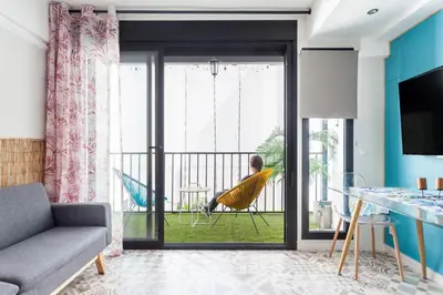 a man sitting in a chair on a balcony at LOFT RUZAFA PLUS in Valencia